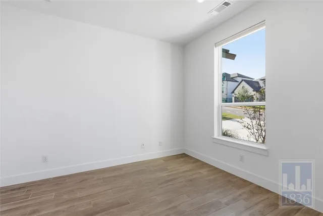 an empty room with wooden floor and window