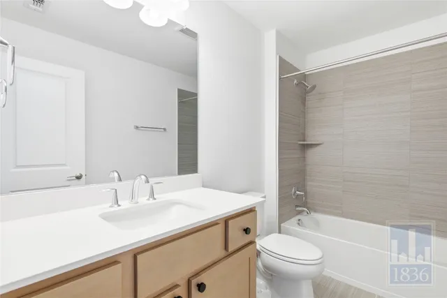 a bathroom with a sink a toilet a mirror a bathtub and shower