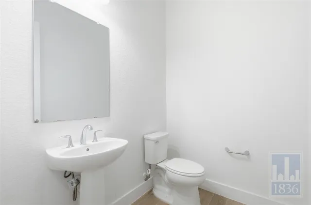 a bathroom with a sink a toilet and a mirror