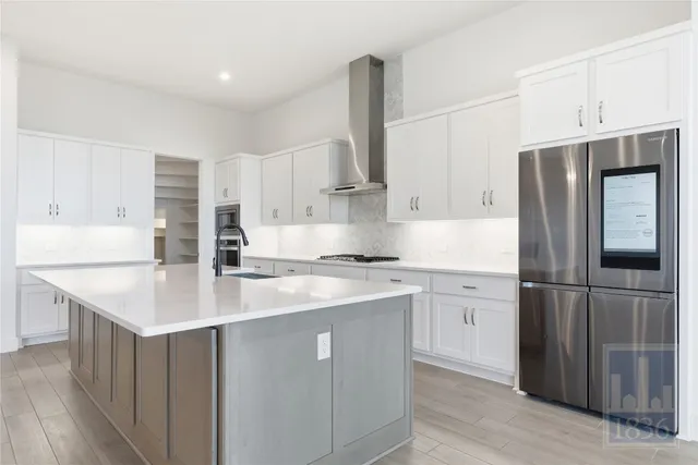 a kitchen with stainless steel appliances a sink stove refrigerator and cabinets
