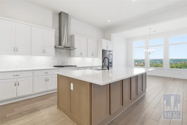 a kitchen with white cabinets appliances a sink and a window