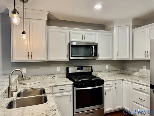 a kitchen with stainless steel appliances kitchen island granite countertop a refrigerator and a stove top oven