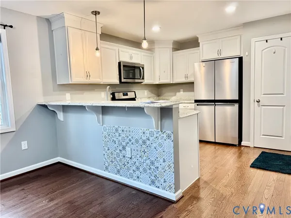 an empty room with windows fireplace and a ceiling fan