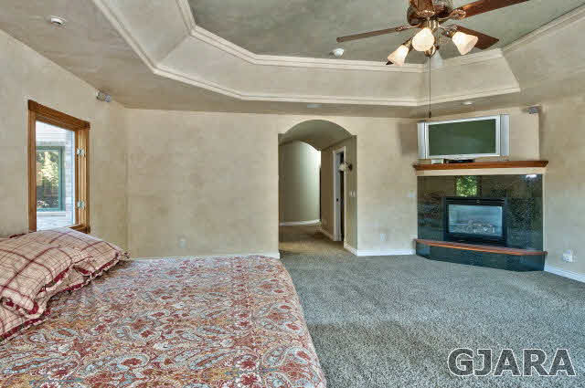 887 25 Road Grand Junction, CO 81505 - Photo 18 of 42 a bedroom with a large bed and a fireplace
