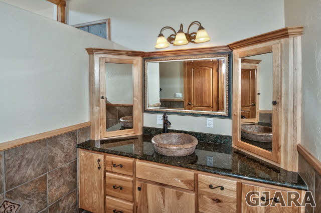 887 25 Road Grand Junction, CO 81505 - Photo 25 of 42 a bathroom with a granite countertop sink and a mirror
