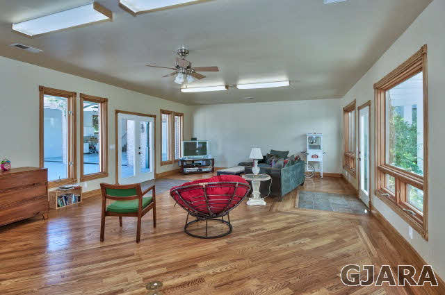 887 25 Road Grand Junction, CO 81505 - Photo 27 of 42 a living room with furniture a wooden floor and a chandelier