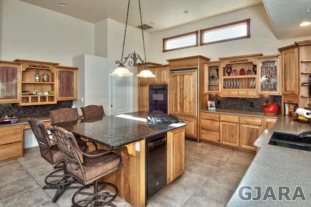 887 25 Road Grand Junction, CO 81505 - Photo 10 of 42 a kitchen with stainless steel appliances granite countertop a stove a kitchen island a dining table and chairs