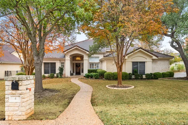 a front view of a house with a yard and tree