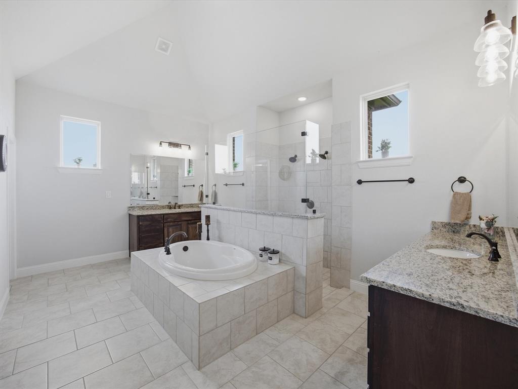 150 Quail Ridge Decatur, TX 76234 - Photo 22 of 32 a bathroom with a sink a mirror and a bath tub