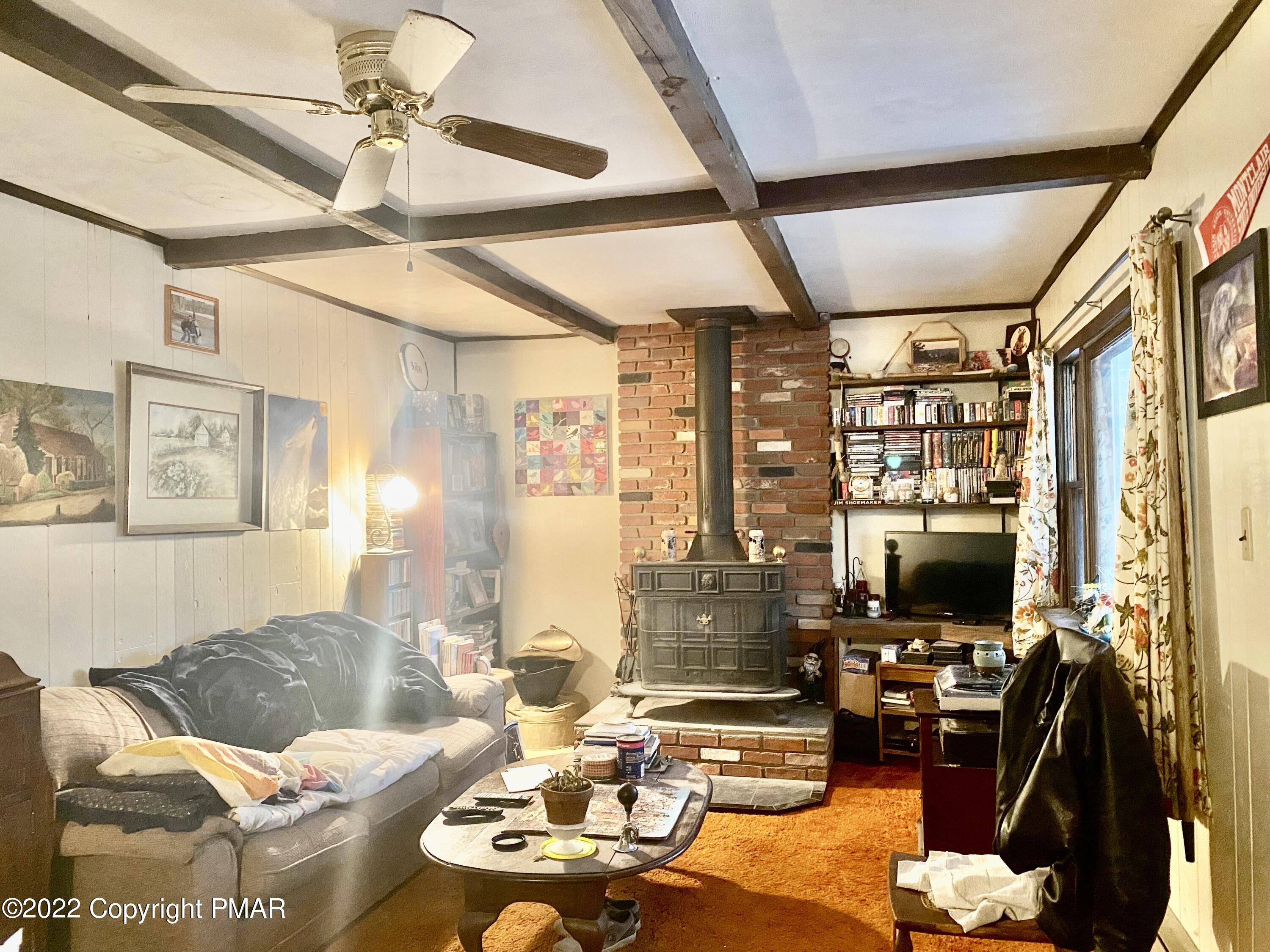 1408 Upper Valley Road Effort, PA 18330 - Photo 6 of 13 a living room with furniture a flat screen tv and a floor to ceiling window