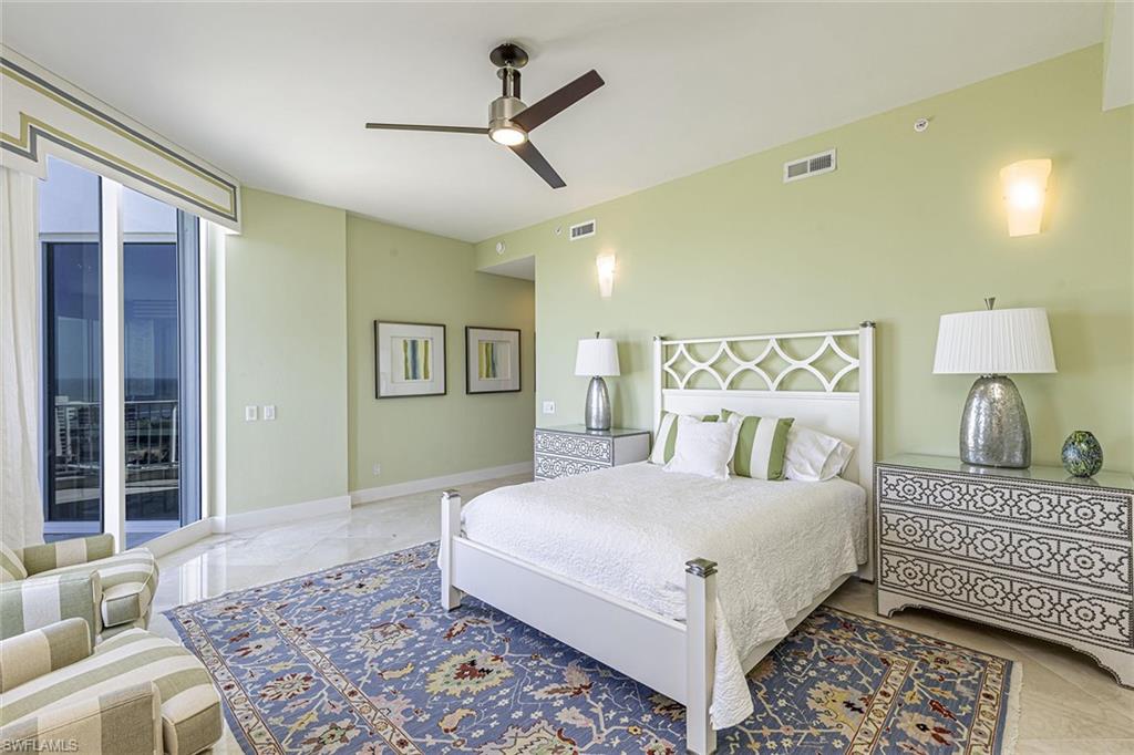 295 Grande Way, Unit PH2 Naples, FL 34110 - Photo 16 of 45 a bedroom with a large bed and a chandelier
