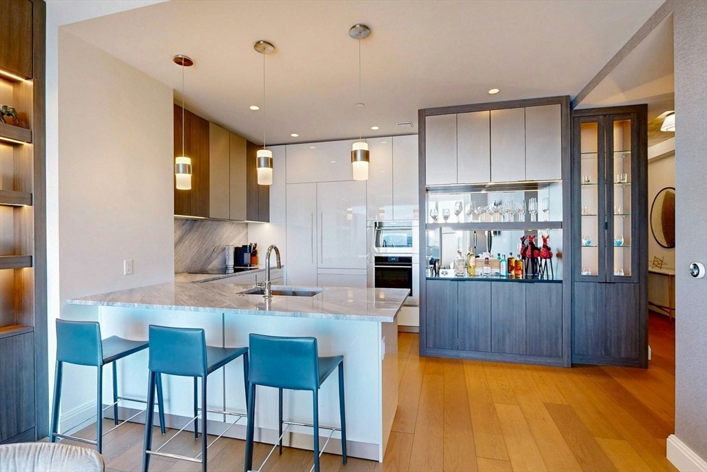 240 Devonshire Street, Unit 4505 Boston, MA 02110 - Photo 13 of 42 a kitchen with kitchen island a stove a table and chairs in it