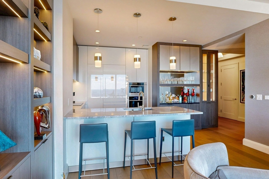 240 Devonshire Street, Unit 4505 Boston, MA 02110 - Photo 14 of 42 a dining hall with stainless steel appliances kitchen island granite countertop a dining table chairs and a refrigerator