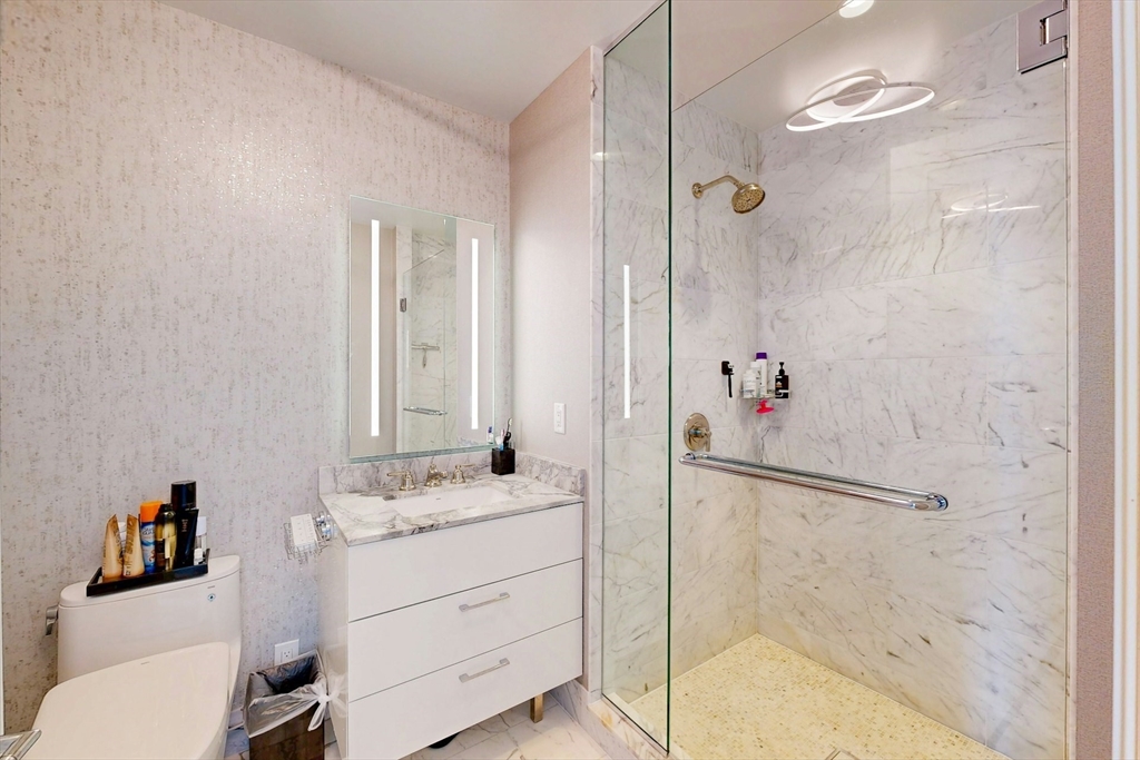 240 Devonshire Street, Unit 4505 Boston, MA 02110 - Photo 21 of 42 a bathroom with a shower sink and mirror