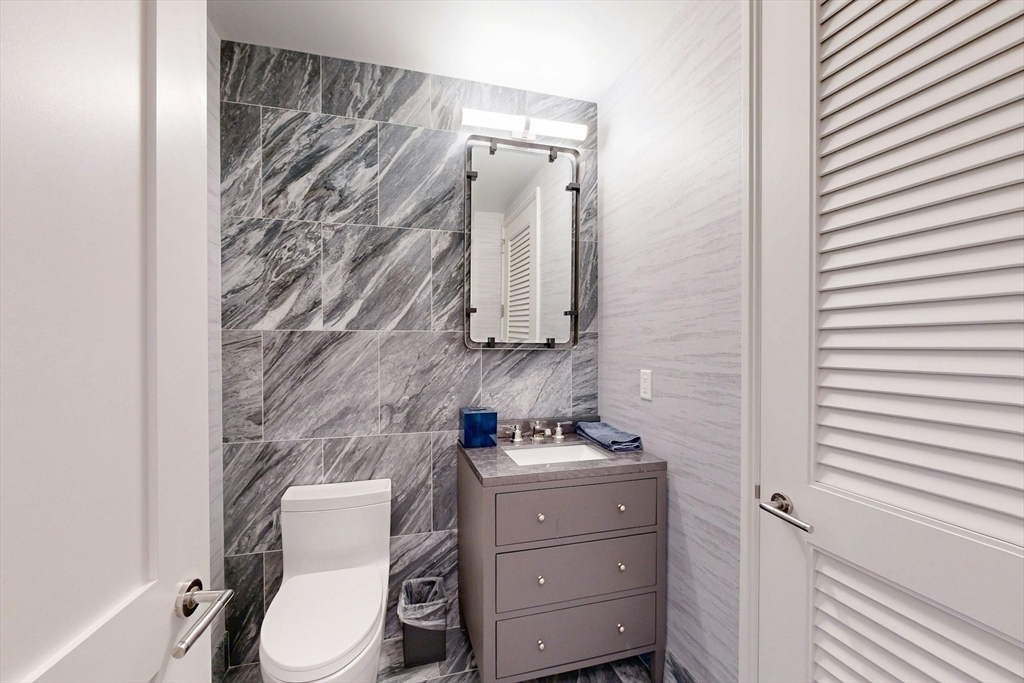 240 Devonshire Street, Unit 4505 Boston, MA 02110 - Photo 25 of 42 a bathroom with a toilet a sink and shower curtain
