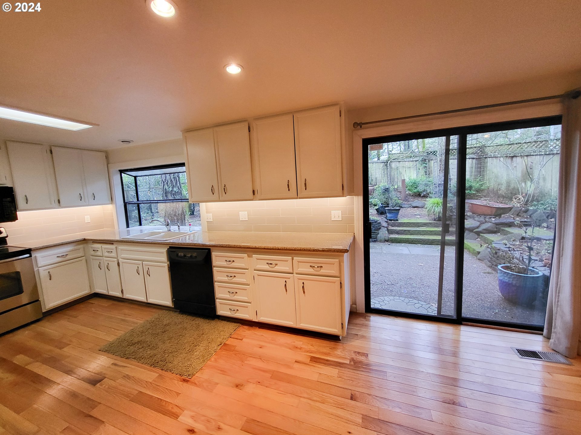 3431 Timberline Drive Eugene, OR 97405 - Photo 19 of 39 a kitchen with stainless steel appliances granite countertop a stove a sink and a refrigerator with wooden floors