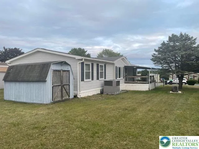 a front view of a house with a garden and trees