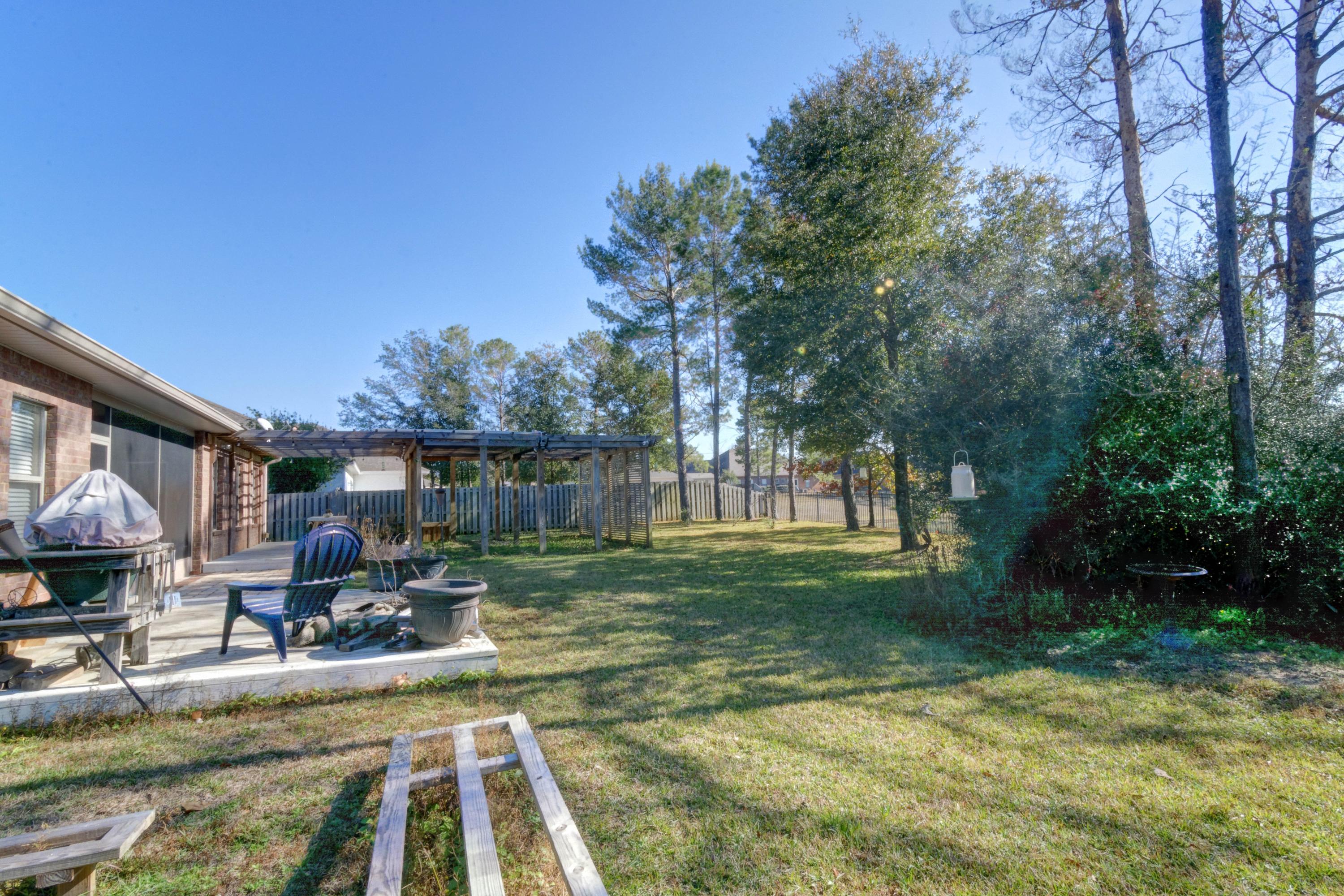 52 Mango Lane Freeport, FL 32439 - Photo 54 of 69 a view of a backyard with table and chairs potted plants and large tree