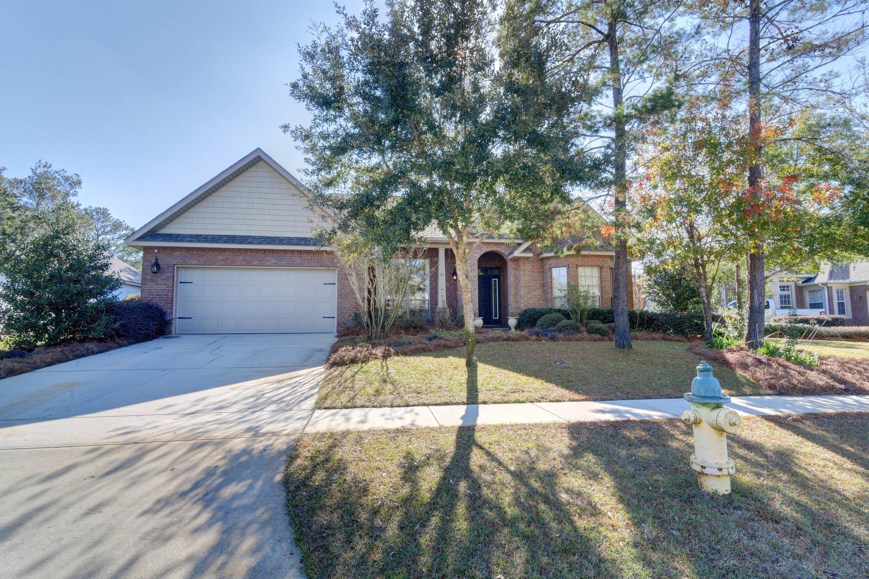 52 Mango Lane Freeport, FL 32439 - Photo 56 of 69 a view of a white house with a small yard and large tree