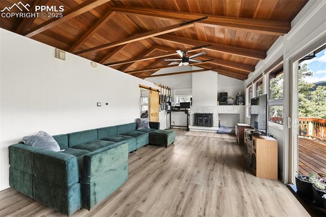 580 Timber Ridge Road Divide, CO 80814 - Photo 8 of 29 Living room with beamed ceilings, walkout to deck and fireplace.