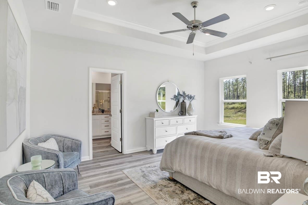 13822 Antler Hl Road Daphne, AL 36527 - Photo 32 of 39 Bedroom featuring ensuite bath, ceiling fan, a raised ceiling, light hardwood / wood-style flooring, and crown molding