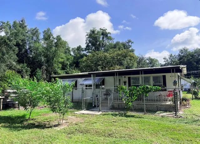 a backyard of a house with lots of green space and plants