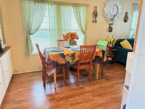 a dining room with furniture a chandelier and wooden floor