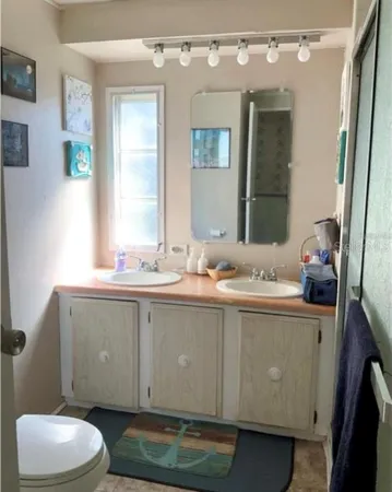 a bathroom with a granite countertop sink a toilet and a mirror