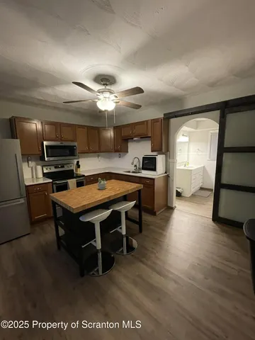 a large kitchen with a table chairs stainless steel appliances and cabinets