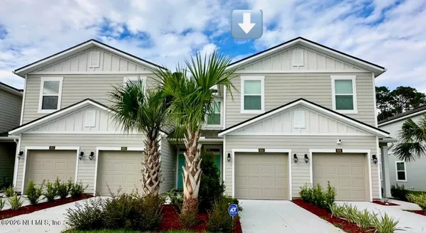a view of a house with a yard plants and palm trees