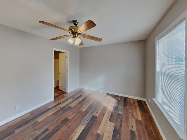 a view of empty room with wooden floor
