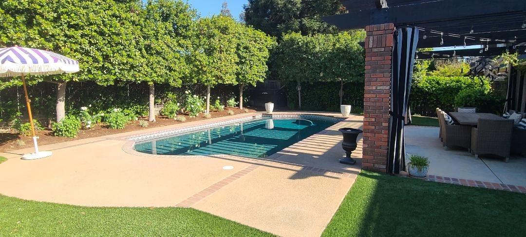 7322 North Geraldine Avenue Fresno, CA 93711 - Photo 17 of 36 a view of a backyard with couches plants and large trees