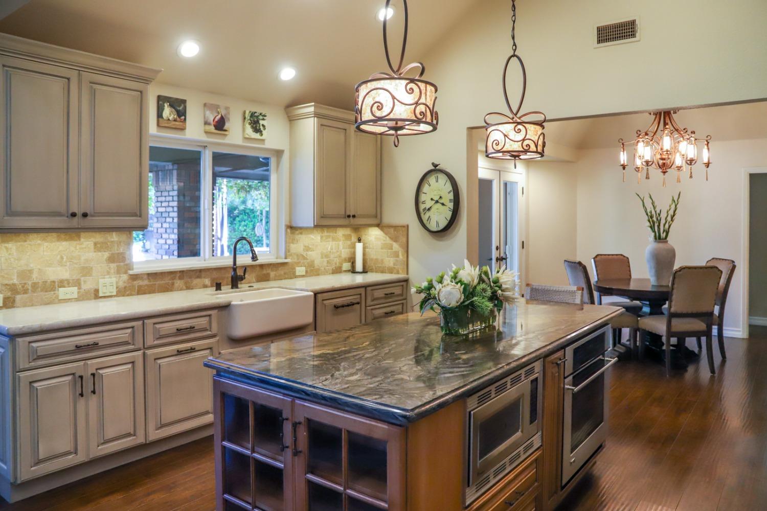 7322 North Geraldine Avenue Fresno, CA 93711 - Photo 3 of 36 a kitchen with a table and a clock on the wall