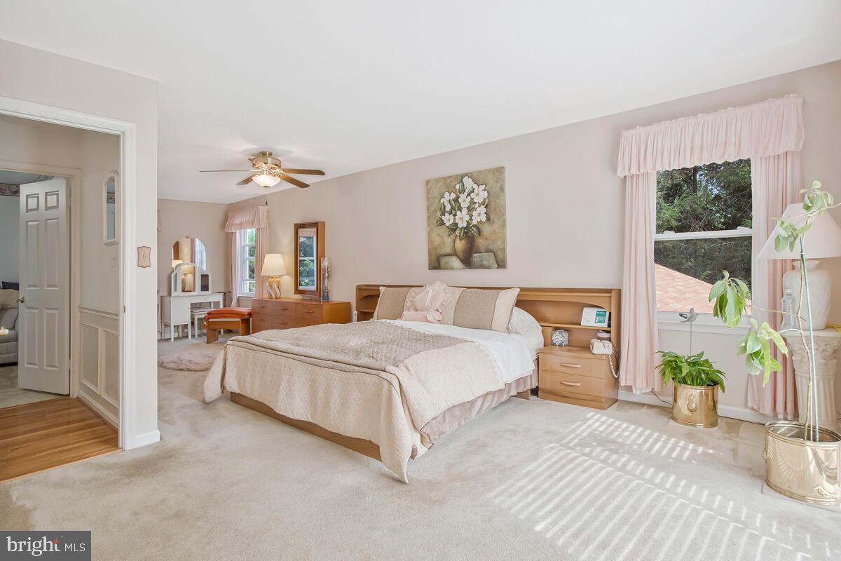 674 Teton Drive Lothian, MD 20711 - Photo 17 of 38 a spacious bedroom with a bed a mirror and a large window