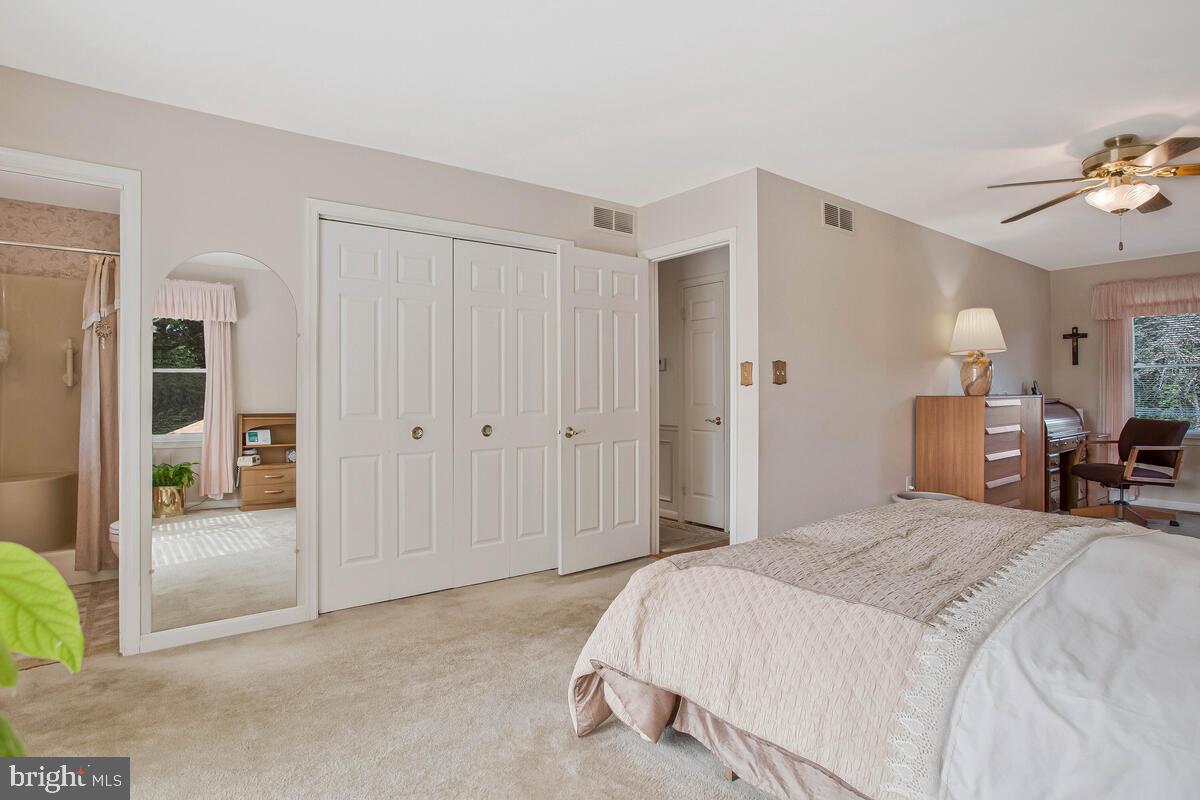 674 Teton Drive Lothian, MD 20711 - Photo 18 of 38 a spacious bedroom with a bed and a chandelier