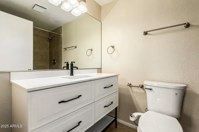 a bathroom with a toilet sink a mirror and a shower