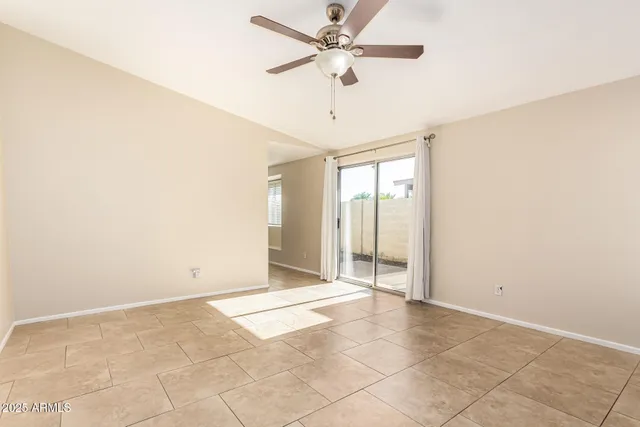 an empty room with a ceiling fan and carpet