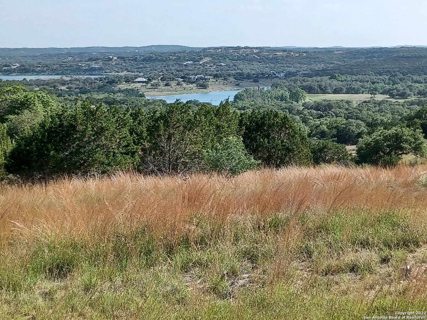 a view of a lake and green valley