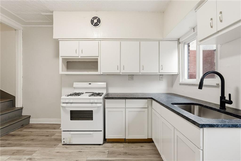 3468 Ligonier Street Pittsburgh, PA 15201 - Photo 13 of 33 a kitchen with white cabinets appliances and sink