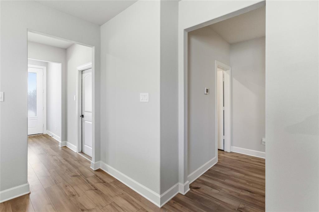 1012 Calhoun Drive Anna, TX 75409 - Photo 15 of 39 Hallway featuring wood-finish flooring, light gray walls, and white trim