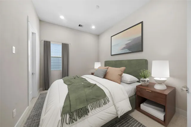 a bedroom with a bed and a painting on the wall