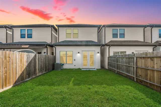 a view of a house with a yard and a large tree
