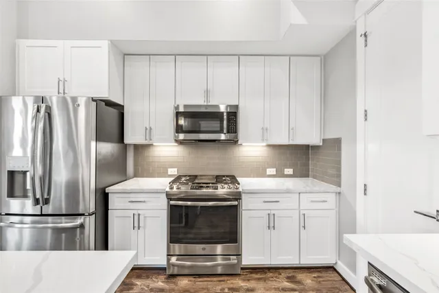 a kitchen with appliances a sink and cabinets
