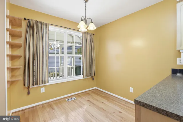 a view of a room with a window and wooden floor