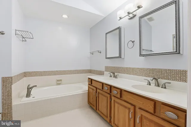 a bathroom with a tub sink and mirror