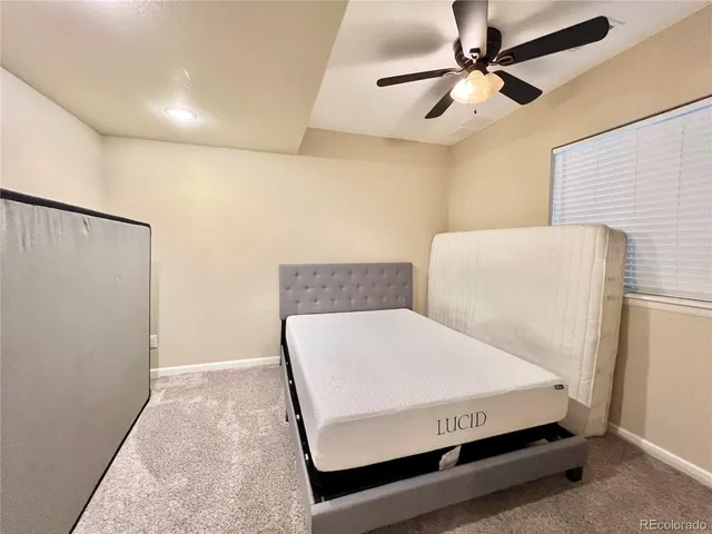a room with a bed and a ceiling fan
