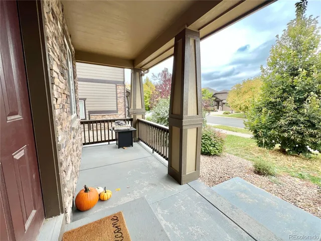 a view of a porch with two chairs and a yard