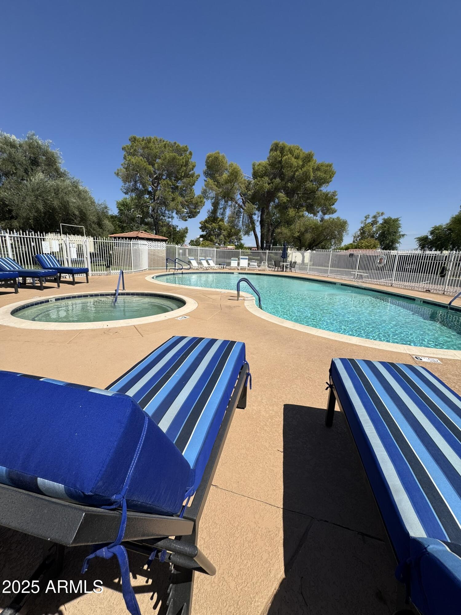 131 North Higley Road, Unit 71 Mesa, AZ 85205 - Photo 13 of 15 a view of a swimming pool with lawn chairs under an umbrella