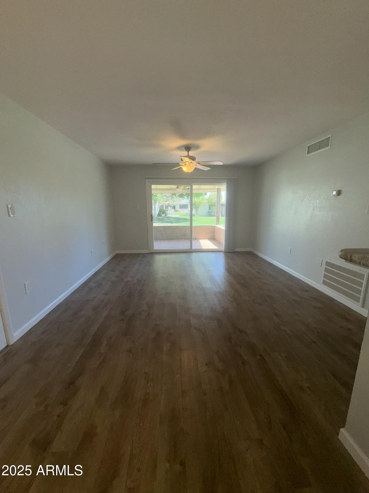 131 North Higley Road, Unit 71 Mesa, AZ 85205 - Photo 2 of 15 an empty room with wooden floor and windows