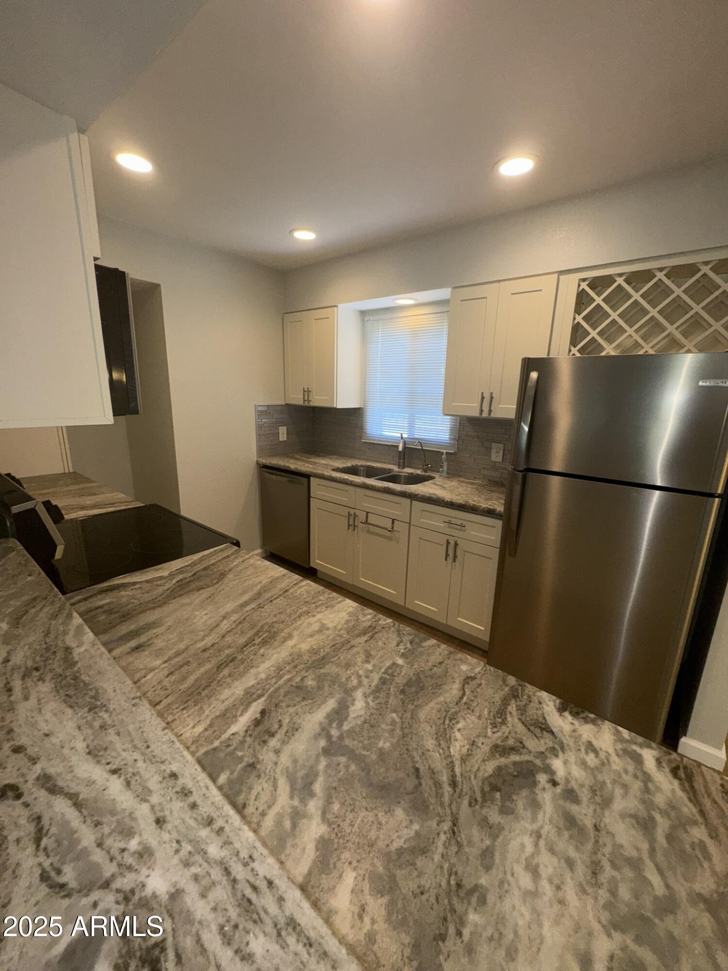 131 North Higley Road, Unit 71 Mesa, AZ 85205 - Photo 4 of 15 a kitchen with granite countertop a refrigerator and a sink